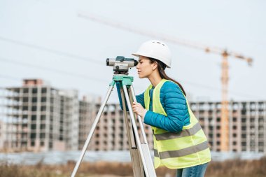 Dijital düzeye sahip araziyi ölçen Ölçümcünün yan görünümü