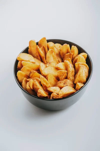 Вкусные Золотые Картофельные Клинья Миске Сером Фоне — стоковое фото