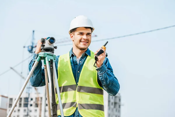Smiling Surveyor Digital Level Talking Radio Set Construction Site Background — Stock Photo, Image