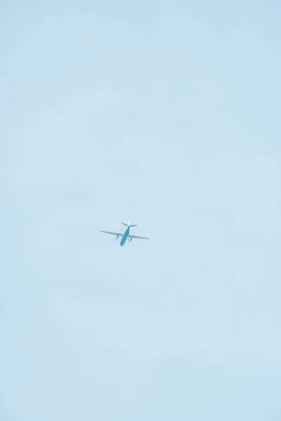 Bottom view of airplane with blue sky at background