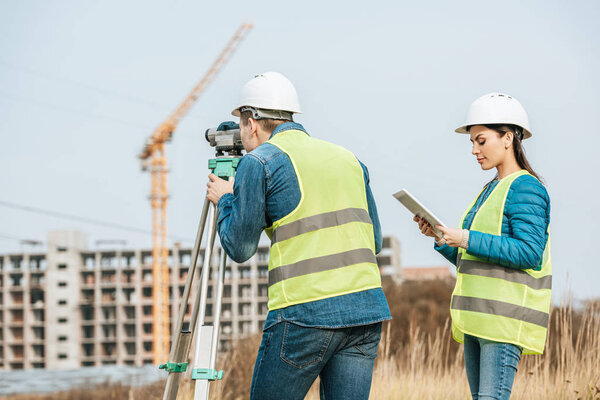 Surveyors working with digital level and tablet in field