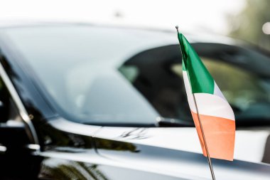Modern siyah arabanın yanındaki İrlanda bayrağının seçici odak noktası 