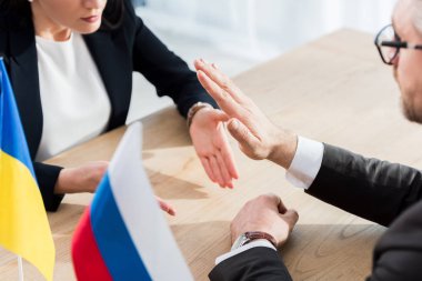 Ukraynalı diplomat ve müzakere sırasında el kol hareketi yapan gözlüklü Rusya büyükelçisi. 