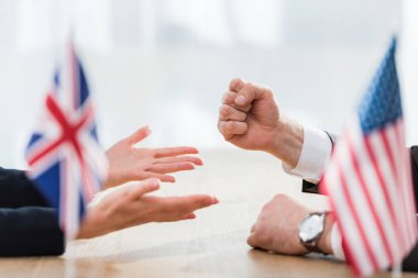 ABD bayrakları ve Birleşik Krallık 'ın bayraklarının yanında el sallayan diplomatlar. 