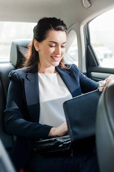 Attractive Ambassador Smiling While Sitting Car Touching Briefcase — Stock Photo, Image