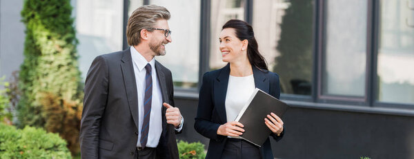 панорамный снимок веселых дипломатов, улыбающихся, глядя друг на друга
 