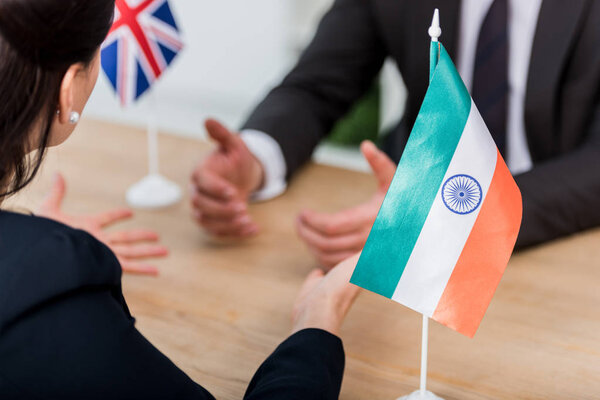 selective focus of diplomat gesturing near flag of india and ambassador of united kingdom 