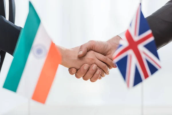 外交官们在印度和联合王国的国旗前握手的剪影 — 图库照片