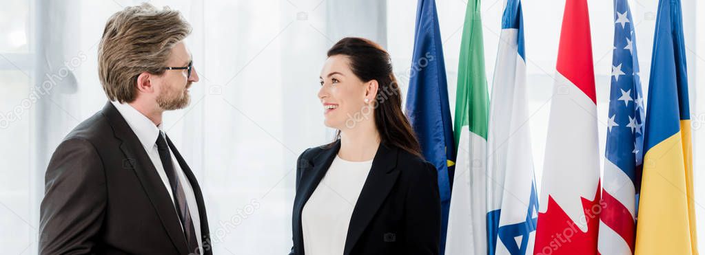 panoramic shot of happy woman looking at diplomat in glasses 