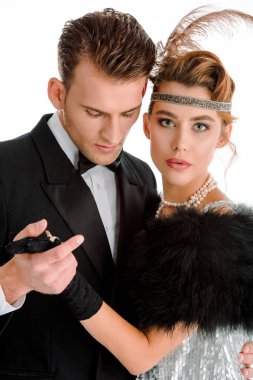 Takım elbiseli yakışıklı adam beyaz tenli aristokrat kadınla el ele tutuşuyor. 