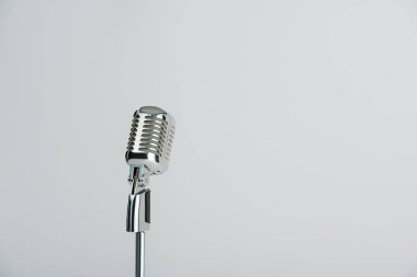 Gri üzerinde kopyalama alanı olan retro mikrofon izole edildi 