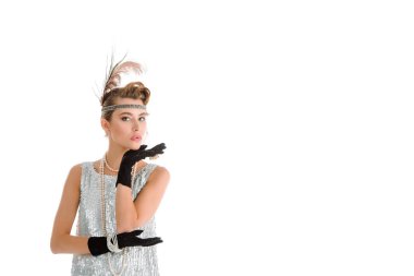 Eldivenli şık bir kadın beyaz kameraya bakıyor. 