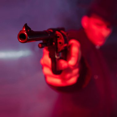 Tehlikeli bir adamın elindeki siyah silahın seçici odağı. 