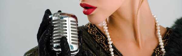 panoramic shot of woman touching retro microphone isolated on grey 