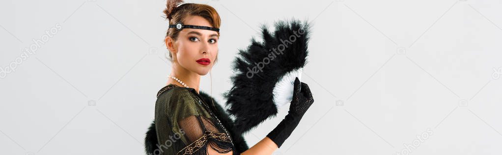 panoramic shot of aristocratic woman holding black feather fan isolated on grey 