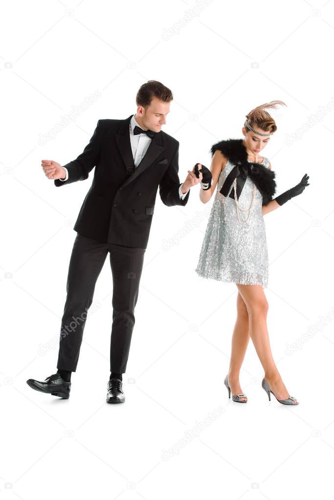 handsome man and woman in dress holding hands while dancing isolated on white 