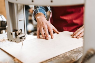 Atölyedeki cnc makinesinin yanındaki zanaatkarın kırpılmış görüntüsü 