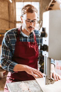 Güvenlik gözlüklü yakışıklı marangoz cnc makinesi kullanıyor. 