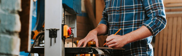 панорамный кадр с карандашом в руках плотника
 