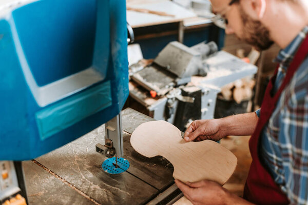 selective focus of cnc machine near bearded woodworker 