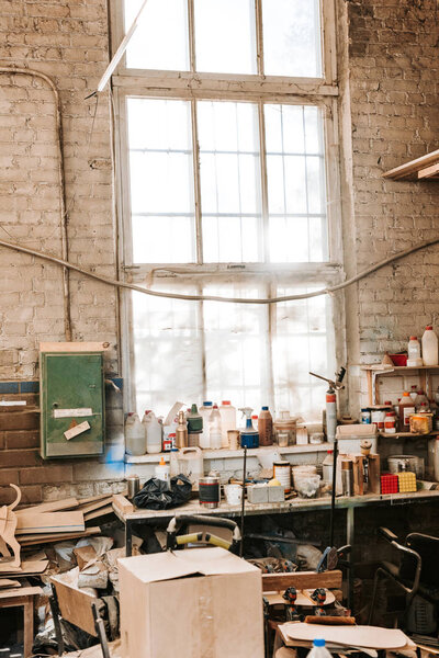 dusty workshop with brick walls and bottles on table 