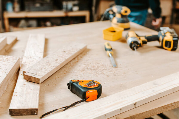 selective focus of wooden planks near measuring tape on table 