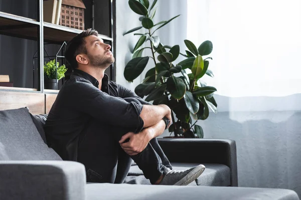 Side View Handsome Man Panic Attack Sitting Sofa Hugging Legs — Stock Photo, Image
