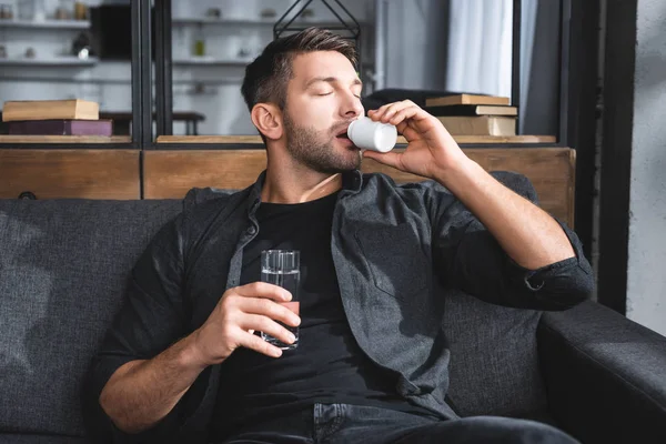 Hombre Guapo Con Ataque Pánico Tomando Pastillas Sosteniendo Vaso Agua —  Fotos de Stock