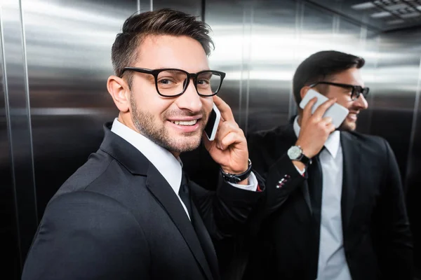 Χαμογελαστός Επιχειρηματίας Κοστούμι Μιλώντας Στο Smartphone Στο Ασανσέρ — Φωτογραφία Αρχείου
