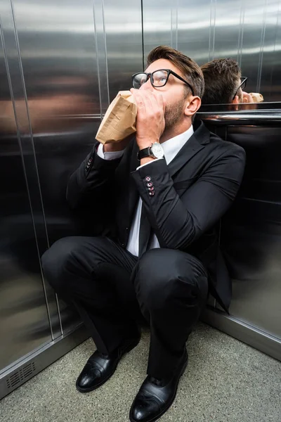 Rémült Üzletember Öltönyben Klausztrofóbiával Légzés Papírzacskóban Liftben — Stock Fotó