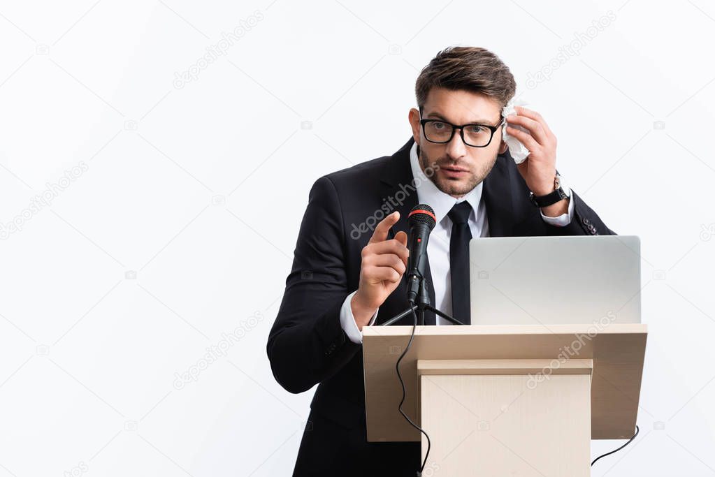 scared businessman in suit standing at podium tribune and speaking during conference isolated on white 