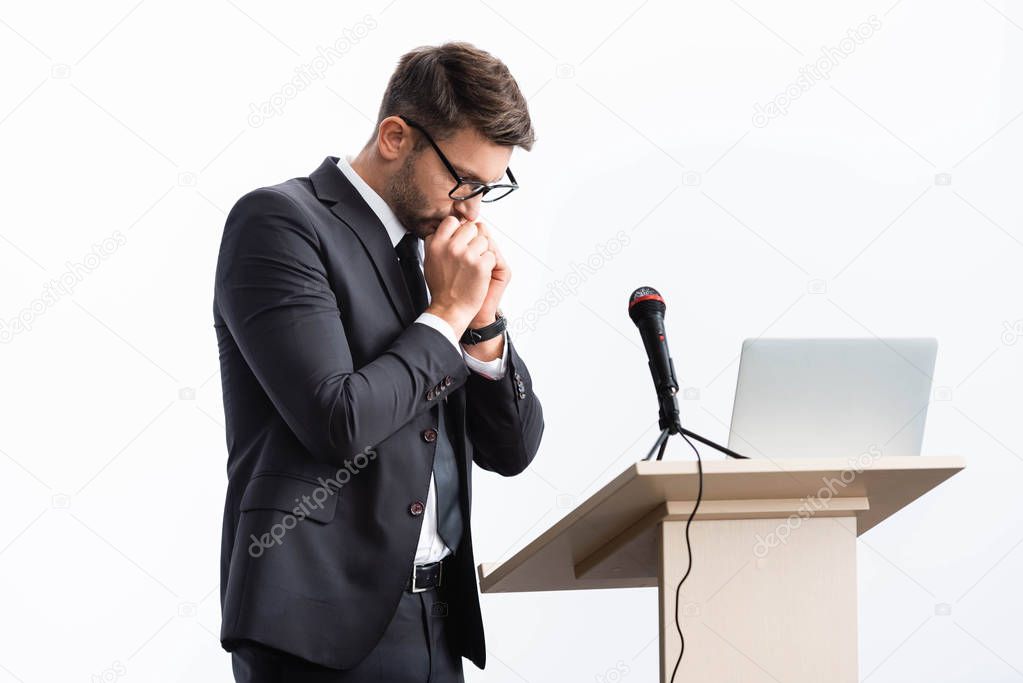 scared businessman in suit standing at podium tribune during conference isolated on white 