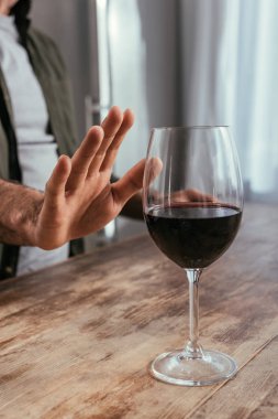 Cropped view of alcohol addicted man pulling hand to wine glass clipart