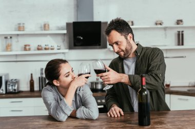 Alkol bağımlısı çift mutfakta şarap içiyor.