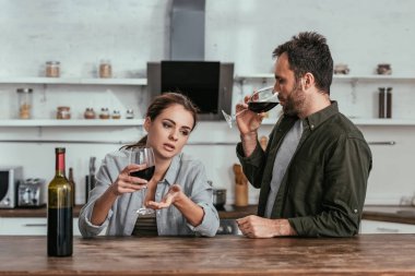 Alkol bağımlısı çift şarap içip mutfakta konuşuyor.