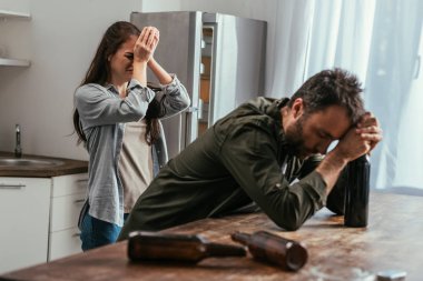 Mutfakta alkol bağımlısı kocası olan ağlayan bir kadının seçici odağı.