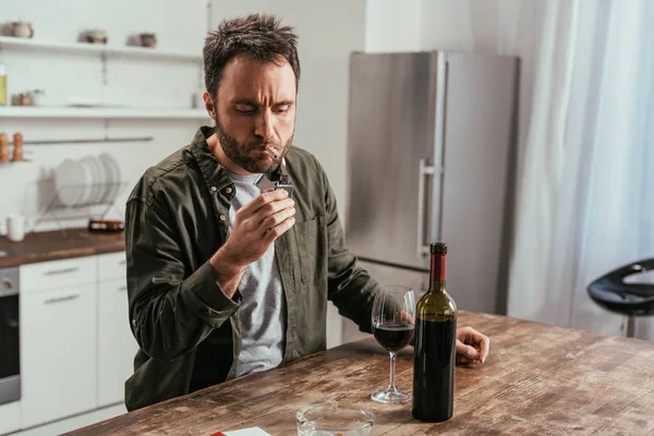 Alkoholsüchtiger Mann Zündet Zigarette Neben Wein Auf Tisch — Stockfoto