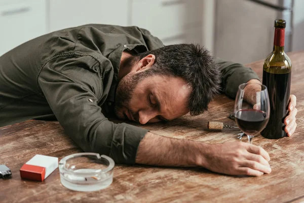 Bêbado Dormindo Mesa Com Vinho Cigarros — Fotografia de Stock