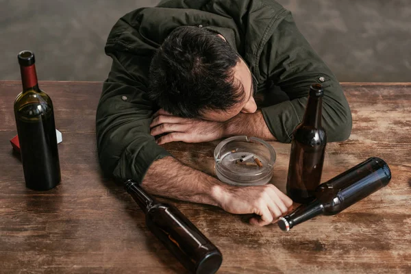 Hoge Hoek Uitzicht Van Dronken Man Liggend Tafel Met Flessen — Stockfoto