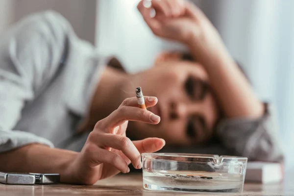 Focus Selettivo Della Donna Che Tiene Sigaretta Dal Posacenere Sul — Foto Stock