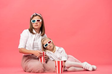 uykulu kız ve anne 3 boyutlu gözlüklerle pembe arka planda patlamış mısır 