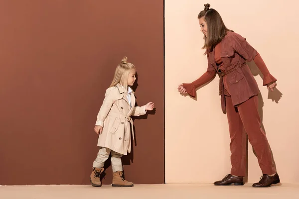 Sidovy Dotter Och Leende Mor Promenader Beige Och Brun Bakgrund — Stockfoto