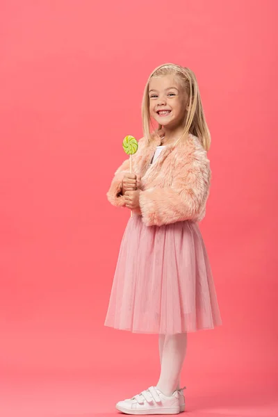 Улыбающийся Милый Ребенок Держит Леденец Розовом Фоне — стоковое фото