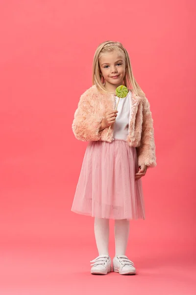 Милый Улыбающийся Ребенок Держит Леденец Розовом Фоне — стоковое фото