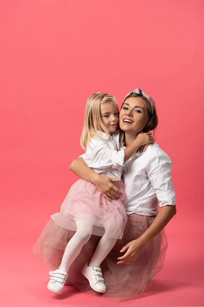 Милая Дочь Обнимает Улыбающуюся Мать Розовом Фоне — стоковое фото