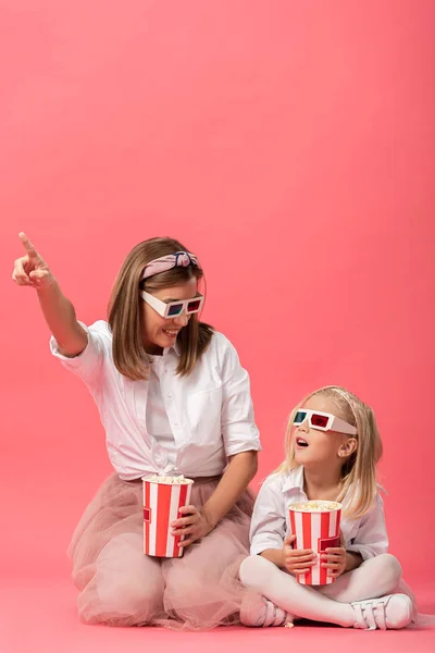 Šokovaná Dcera Popcornem Matka Ukazuje Prstem Růžové Pozadí — Stock fotografie
