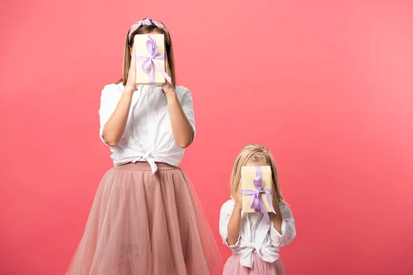 女儿和母亲用粉色隔离的礼物蒙着脸 — 图库照片