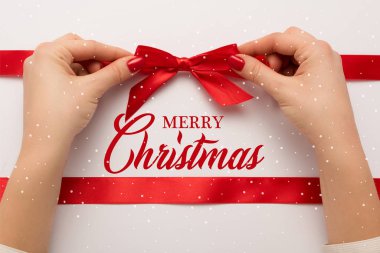 Kırmızıya dokunan bir kadının görüntüsü Mutlu noel yazıtlarının yanında beyaz 