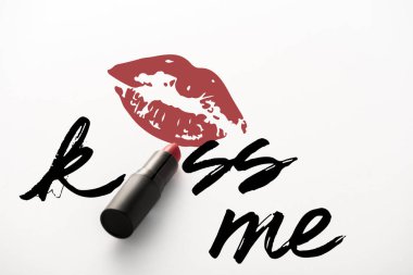 black tube with red lipstick near kiss me letters and kiss print on white  clipart