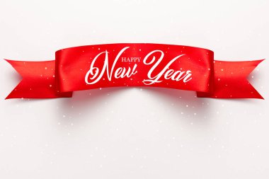 Kırmızı saten kurdelenin üst görüntüsü ve beyaz üzerine yeni yıl harfi. 